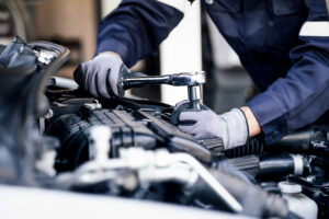 Professional mechanic working on the engine of the car in the garage performing Vehicle Repairs in Bristol