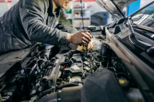 Close up of a mechanic fixing a car under the hood with tools